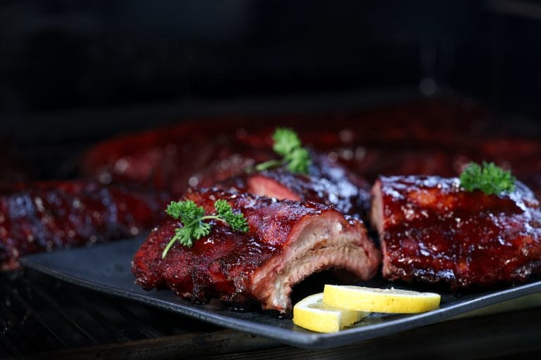 Smoked ribs grilled to perfection and garnished with parsley and lemon